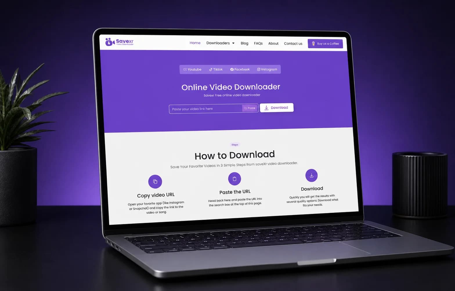 SaveXR online video downloader displayed on a laptop in a purple studio setting